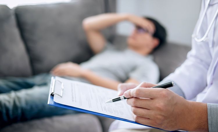A man suffering from pregabalin withdrawal symptoms lying on a consultation sofa - Step by Step Recovery