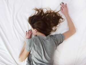 woman laid face down on bed